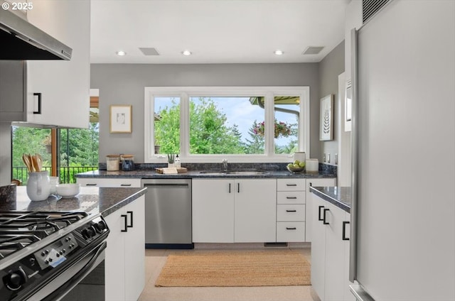 3132 SW Altadena Ter, Portland, OR 97239 - kitchen featuring refrigerator, stainless steel dishwasher, under cabinet range hood, a sink, and white cabinetry