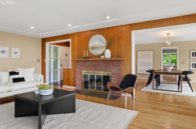 3132 SW Altadena Ter, Portland, OR 97239 - living room with light wood-style flooring, a fireplace, recessed lighting, wooden walls, and baseboards