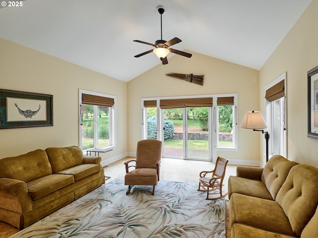 living room with ceiling fan, a healthy amount of sunlight, light carpet, and vaulted ceiling