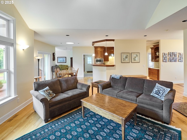 living room featuring light hardwood / wood-style flooring and vaulted ceiling