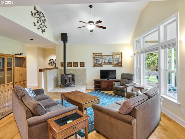 living room featuring plenty of natural light, light hardwood / wood-style floors, and a wood stove