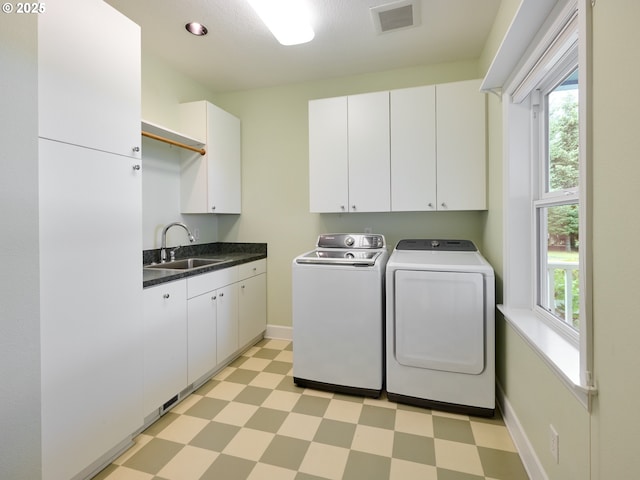 washroom featuring cabinets, sink, and washer and dryer