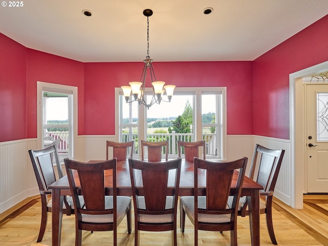 dining area with light hardwood / wood-style flooring and a notable chandelier