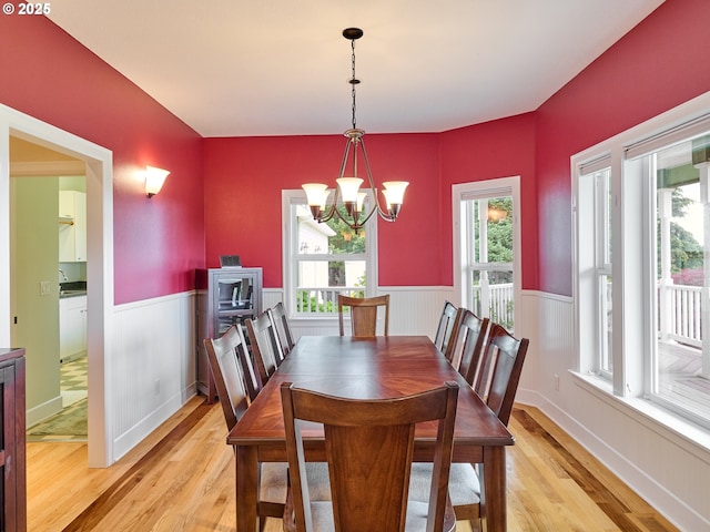 dining area with light wood-type flooring and an inviting chandelier