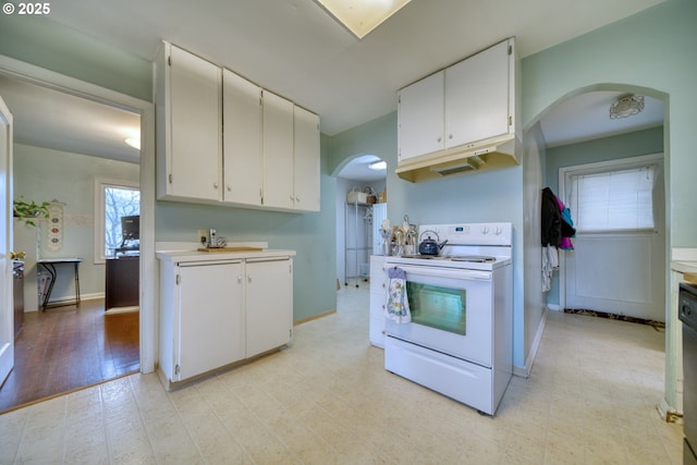 kitchen with light countertops, white range with electric stovetop, arched walkways, and white cabinets