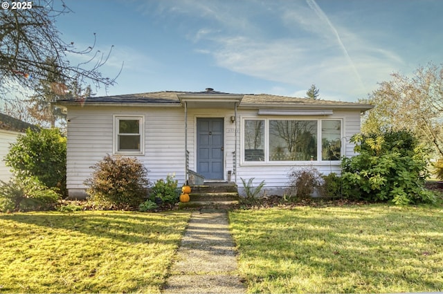 bungalow-style home featuring a front yard and entry steps