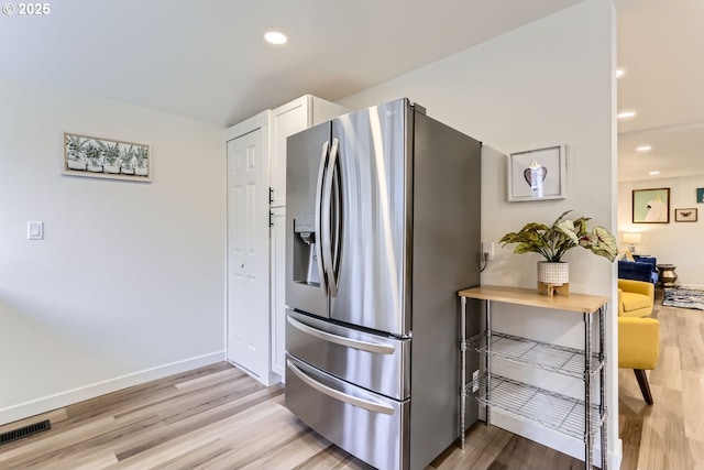 kitchen featuring light wood-type flooring, white cabinets, and stainless steel refrigerator with ice dispenser