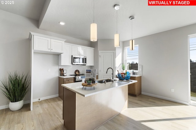 1203 NE Emerald Dr, Hermiston, OR 97838 - kitchen featuring appliances with stainless steel finishes, light wood-style floors, white cabinetry, light countertops, and recessed lighting