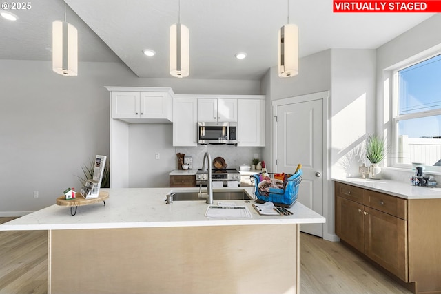 1203 NE Emerald Dr, Hermiston, OR 97838 - kitchen with stainless steel microwave, light wood-type flooring, white cabinetry, decorative light fixtures, and recessed lighting