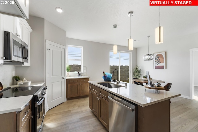 1203 NE Emerald Dr, Hermiston, OR 97838 - kitchen featuring appliances with stainless steel finishes, light wood-type flooring, pendant lighting, recessed lighting, and a kitchen island with sink