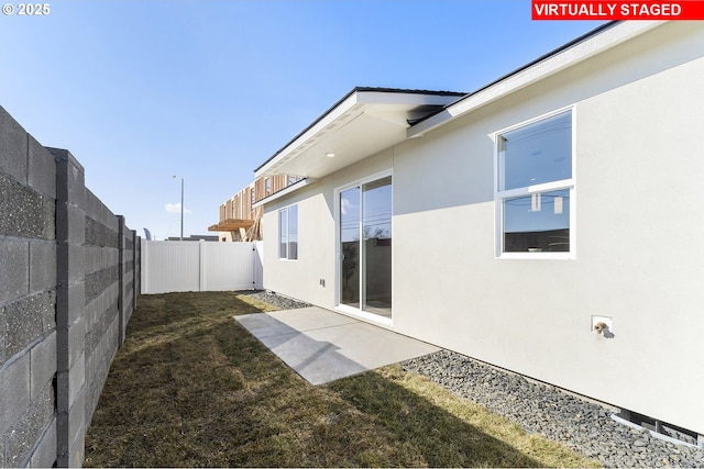 1203 NE Emerald Dr, Hermiston, OR 97838 - rear view of property featuring stucco siding, a fenced backyard, and a patio area