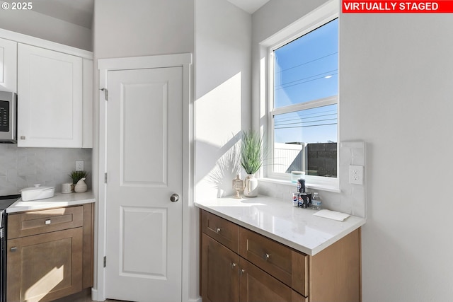 1203 NE Emerald Dr, Hermiston, OR 97838 - kitchen featuring plenty of natural light, tasteful backsplash, white cabinetry, and light countertops