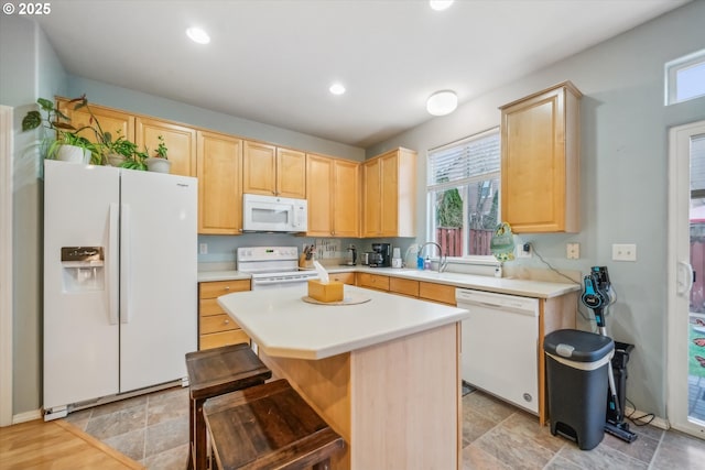 kitchen with light brown cabinetry, white appliances, light countertops, and recessed lighting