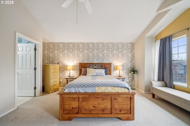 carpeted bedroom with wallpapered walls, baseboards, ceiling fan, an accent wall, and vaulted ceiling