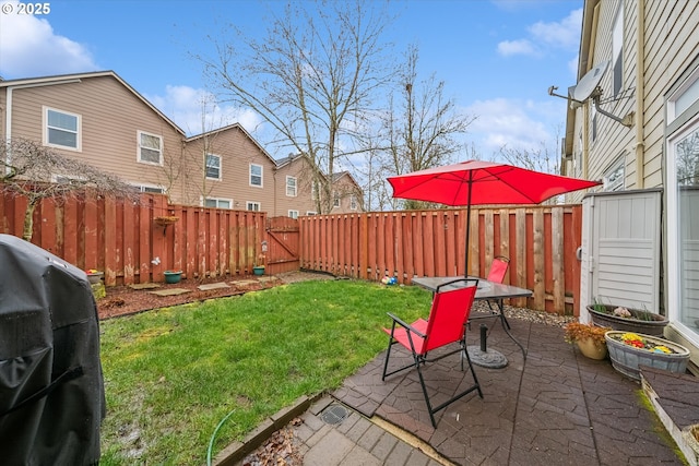 view of yard featuring a patio area, a fenced backyard, and a gate