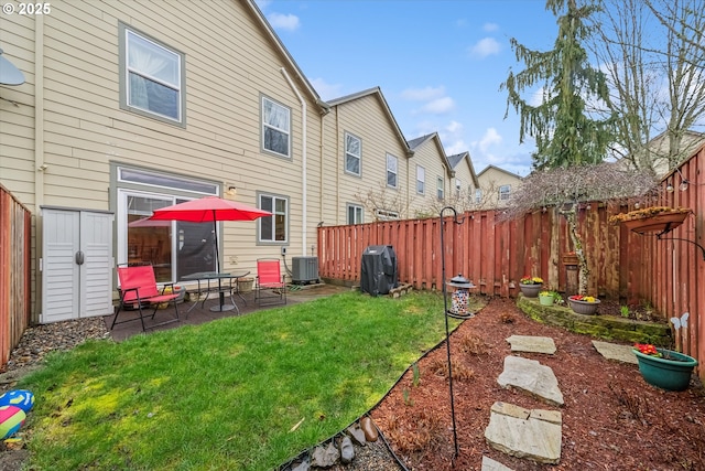 back of property with a patio, central AC unit, a fenced backyard, a yard, and a residential view