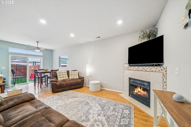 living room featuring a fireplace, wood finished floors, visible vents, and recessed lighting