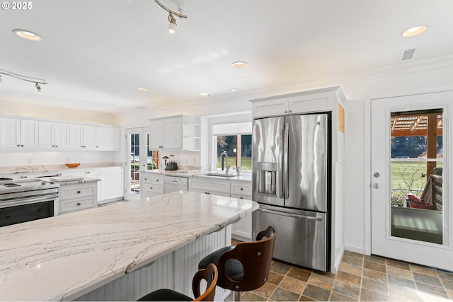 9202 Phey Ln, Florence, OR 97439 - kitchen featuring open shelves, appliances with stainless steel finishes, a sink, stone finish floor, and visible vents