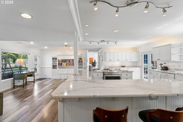 9202 Phey Ln, Florence, OR 97439 - kitchen with open shelves, a kitchen breakfast bar, stainless steel range, and ornamental molding