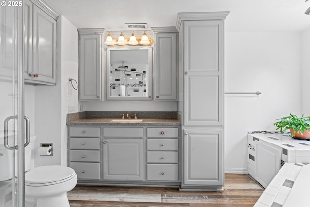 9202 Phey Ln, Florence, OR 97439 - full bathroom with visible vents, wood finished floors, toilet, and vanity
