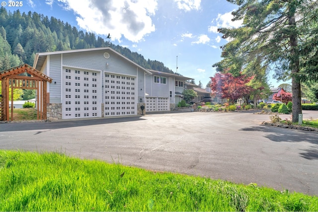 9202 Phey Ln, Florence, OR 97439 - view of property exterior with a garage, aphalt driveway, and stone siding