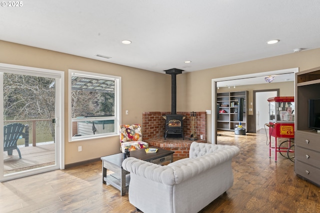 9202 Phey Ln, Florence, OR 97439 - living area with a wood stove, recessed lighting, wood finished floors, and visible vents