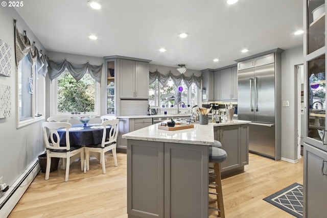 13720 SW Butner Rd, Beaverton, OR 97005 - kitchen featuring gray cabinets, a baseboard radiator, built in fridge, decorative backsplash, and healthy amount of natural light
