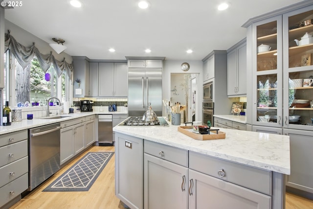 13720 SW Butner Rd, Beaverton, OR 97005 - kitchen with gray cabinets, built in appliances, a sink, tasteful backsplash, and light wood-style floors