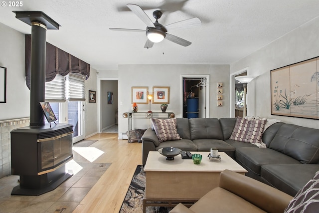 13720 SW Butner Rd, Beaverton, OR 97005 - living room with a wood stove, a ceiling fan, wood finished floors, and a textured ceiling