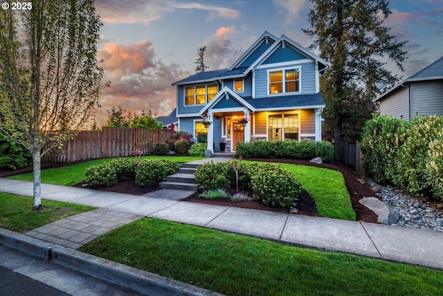 craftsman house featuring a porch, fence, and a front yard