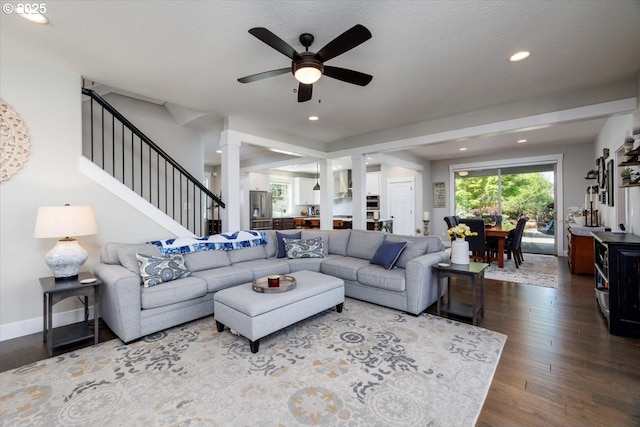 living area featuring stairs, ceiling fan, ornate columns, recessed lighting, and dark wood finished floors