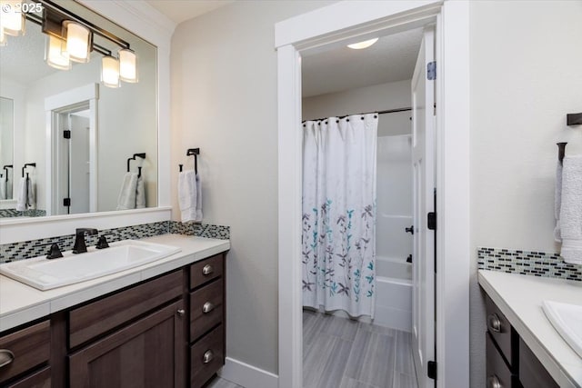 full bathroom featuring vanity, decorative backsplash, baseboards, and shower / tub combo with curtain