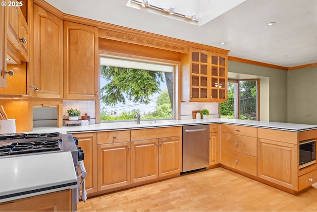 1228 11th St, Astoria, OR 97103 - kitchen with appliances with stainless steel finishes, light wood-style floors, a peninsula, decorative backsplash, and glass insert cabinets