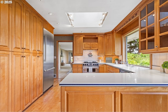 1228 11th St, Astoria, OR 97103 - kitchen with high quality appliances, light countertops, glass insert cabinets, decorative backsplash, and recessed lighting