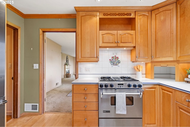 1228 11th St, Astoria, OR 97103 - kitchen with stainless steel range, light countertops, tasteful backsplash, light wood-type flooring, and crown molding