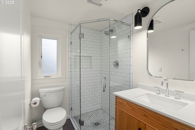 full bathroom featuring a stall shower, toilet, vanity, and tile patterned floors