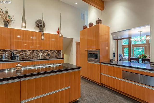 11 Da Vinci St, Lake Oswego, OR 97035 - kitchen featuring stainless steel microwave, a chandelier, a towering ceiling, modern cabinets, and decorative backsplash
