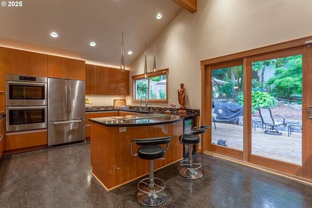 11 Da Vinci St, Lake Oswego, OR 97035 - kitchen featuring stainless steel appliances, brown cabinets, a peninsula, recessed lighting, and dark countertops