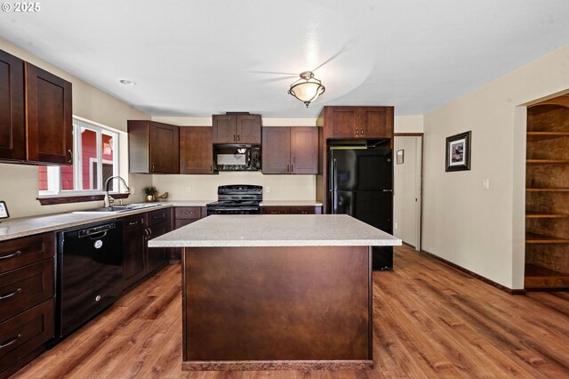 290 12th Ave, Hammond, OR 97121 - kitchen featuring black appliances, a sink, a center island, wood finished floors, and light countertops