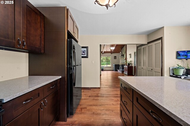 290 12th Ave, Hammond, OR 97121 - kitchen featuring light wood-type flooring, freestanding refrigerator, dark brown cabinetry, light countertops, and open floor plan
