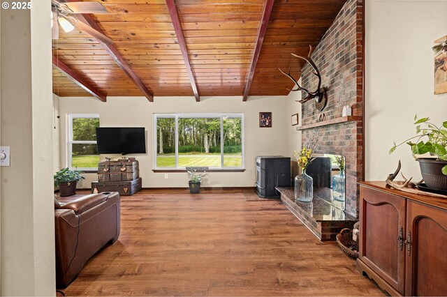 290 12th Ave, Hammond, OR 97121 - living area featuring wooden ceiling with exposed beams, healthy amount of natural light, wood finished floors, a ceiling fan, and a fireplace