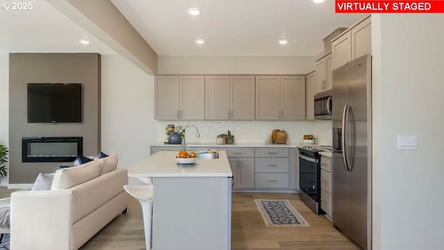 17197 SE Maple Hill Ln, Happy Valley, OR 97086 - kitchen with appliances with stainless steel finishes, open floor plan, light countertops, decorative backsplash, and light wood-type flooring