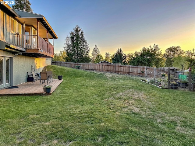 130 Terrace Dr, Glide, OR 97443 - yard at dusk featuring a fenced backyard, a balcony, a vegetable garden, and a wooden deck