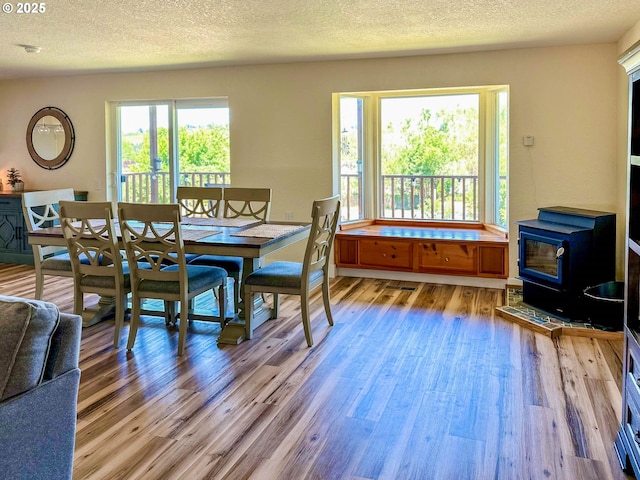 130 Terrace Dr, Glide, OR 97443 - dining area featuring light wood-style floors, a textured ceiling, and a wood stove