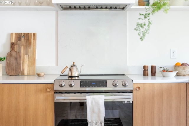 3511 NE Rosa Parks Way, Portland, OR 97211 - kitchen with stainless steel electric range oven, modern cabinets, ventilation hood, and light countertops