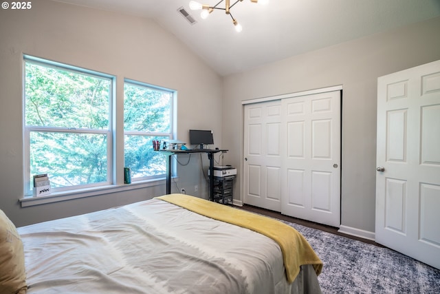 bedroom featuring a closet, baseboards, visible vents, lofted ceiling, and a notable chandelier