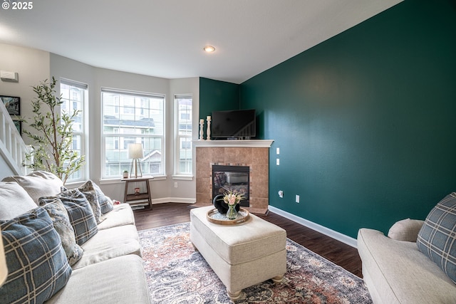 living room with a fireplace, wood finished floors, and baseboards