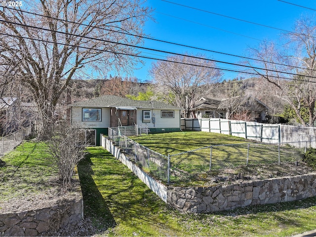 view of front of property featuring a fenced front yard and a front lawn