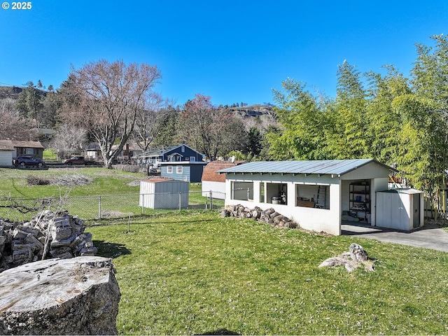 view of yard featuring an outdoor structure and fence