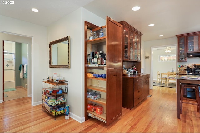 bar with light wood-type flooring, baseboards, ventilation hood, and recessed lighting